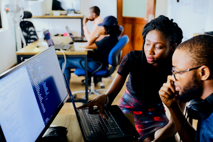 Young professionals collaborating around laptops